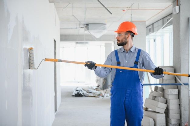 Homem pintando uma parede com rolo