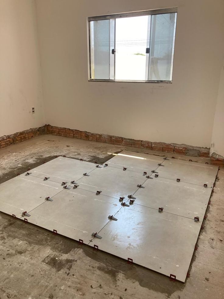 Profissional assentando porcelanato no chão